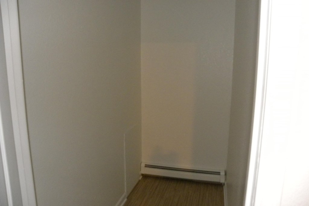 an empty room with white walls and a wooden floor