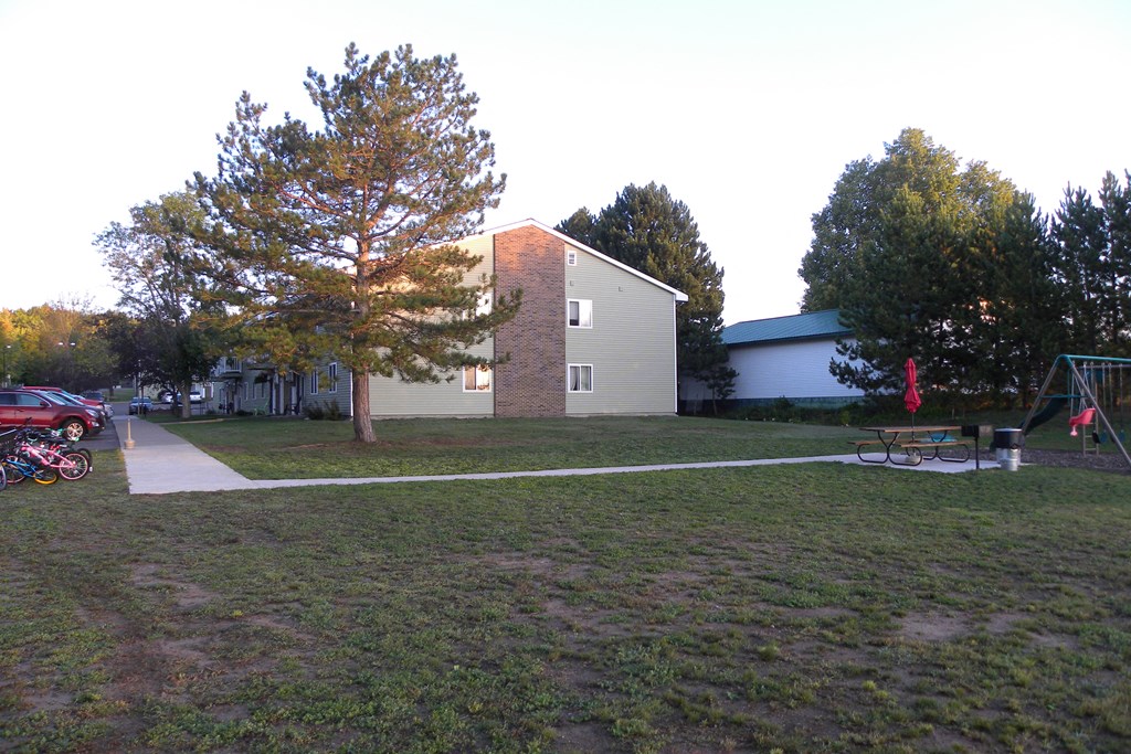 a yard in front of a house with a playground