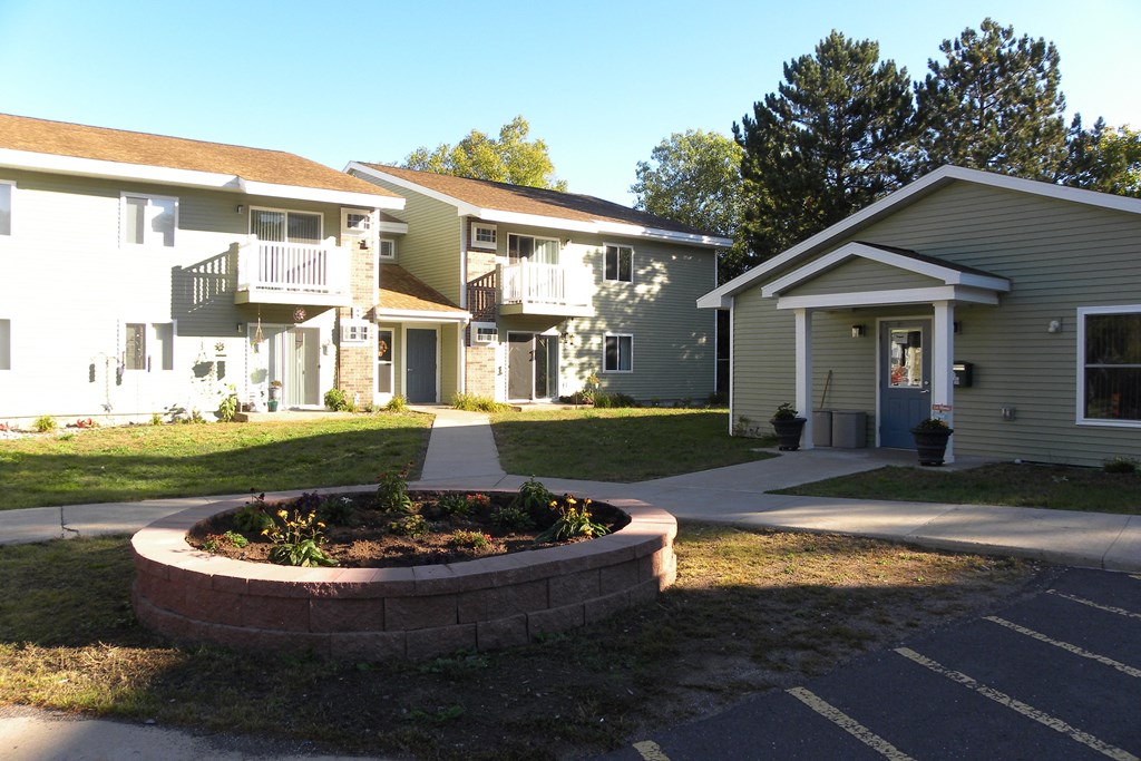 an outside view of some apartments with a garden in front of them