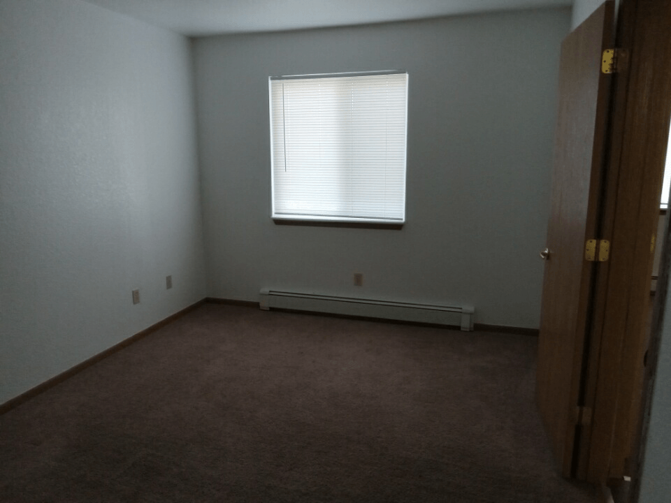 an empty room with a window and a door