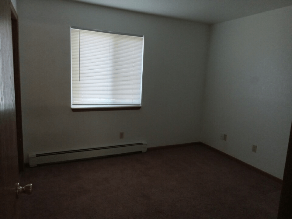 an empty room with a window and a door