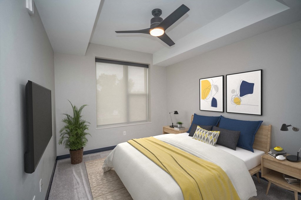 a bedroom with a large bed with a yellow blanket and blue pillows