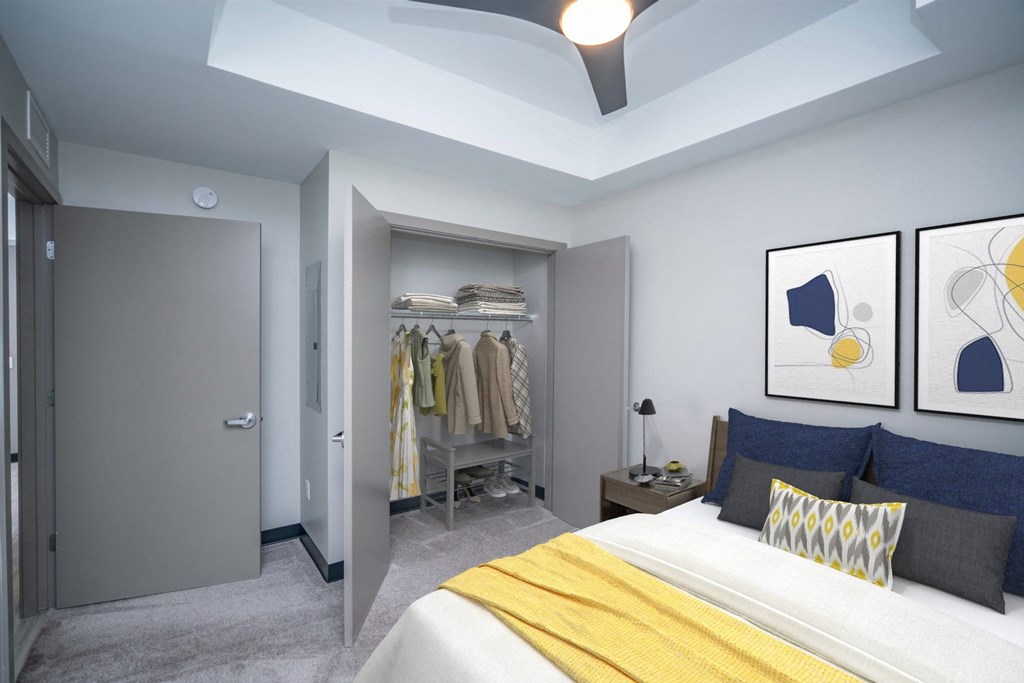 a bedroom with grey walls and a yellow blanket on the bed