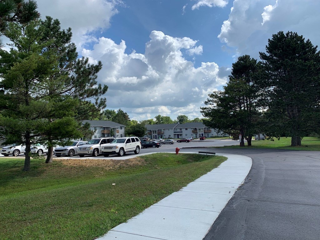 a city street with cars parked in front of houses