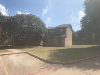 a house with a driveway and trees in front of it