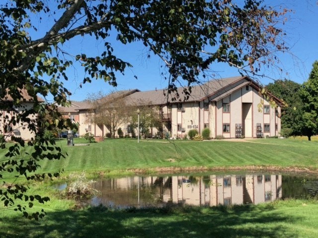 a large building with a pond in front of it