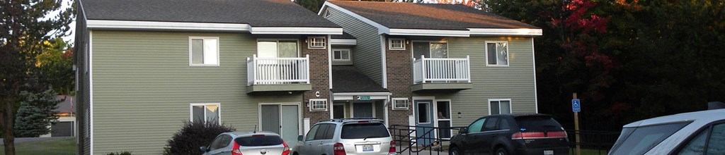 an apartment building with cars parked in front of it