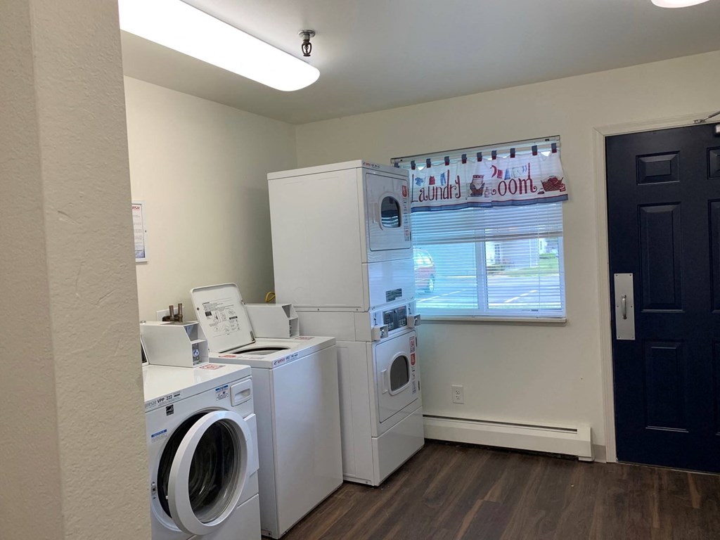 a laundry room with two washing machines and a washer and dryer