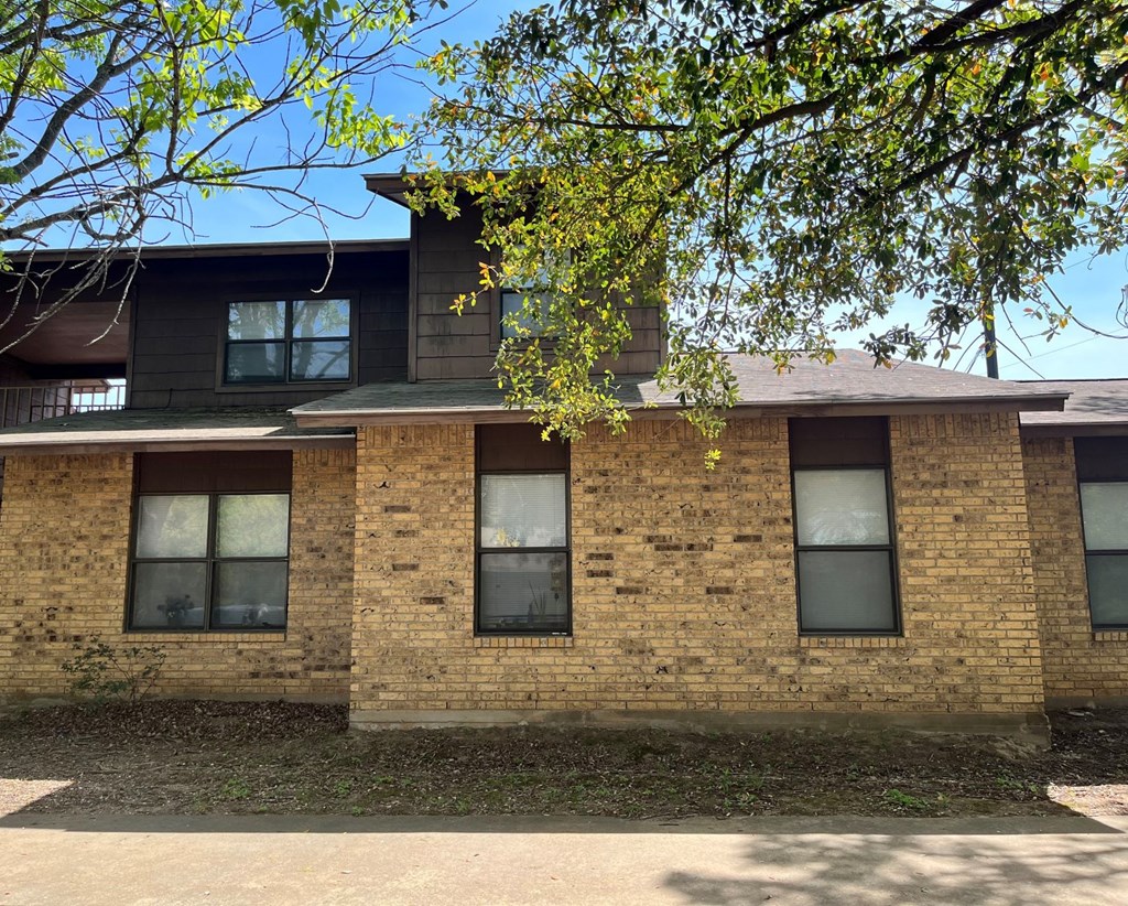 a brick building with a tree in front of it