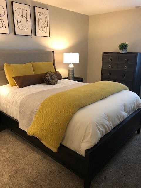 a bedroom with a bed with a yellow blanket