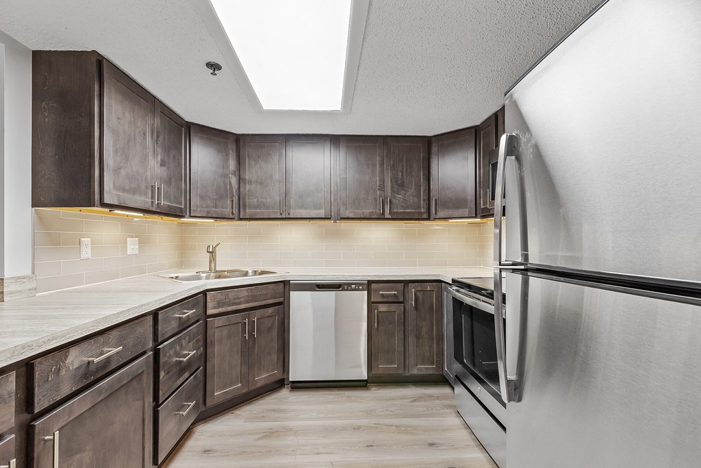 a kitchen with dark wood cabinets and white appliances