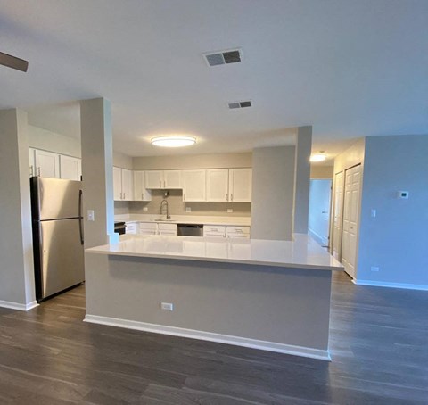 a kitchen with white cabinets and a stainless steel refrigerator