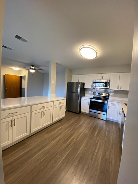 a kitchen with white cabinets and stainless steel appliances