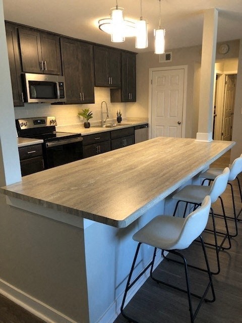 a kitchen with a large island with four chairs