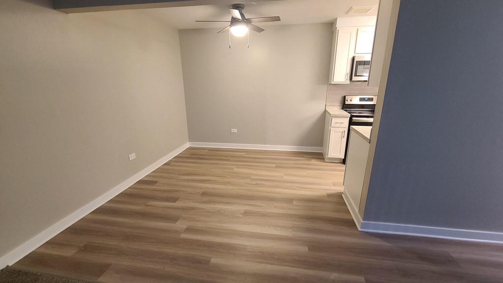 a living room with wood flooring and a ceiling fan