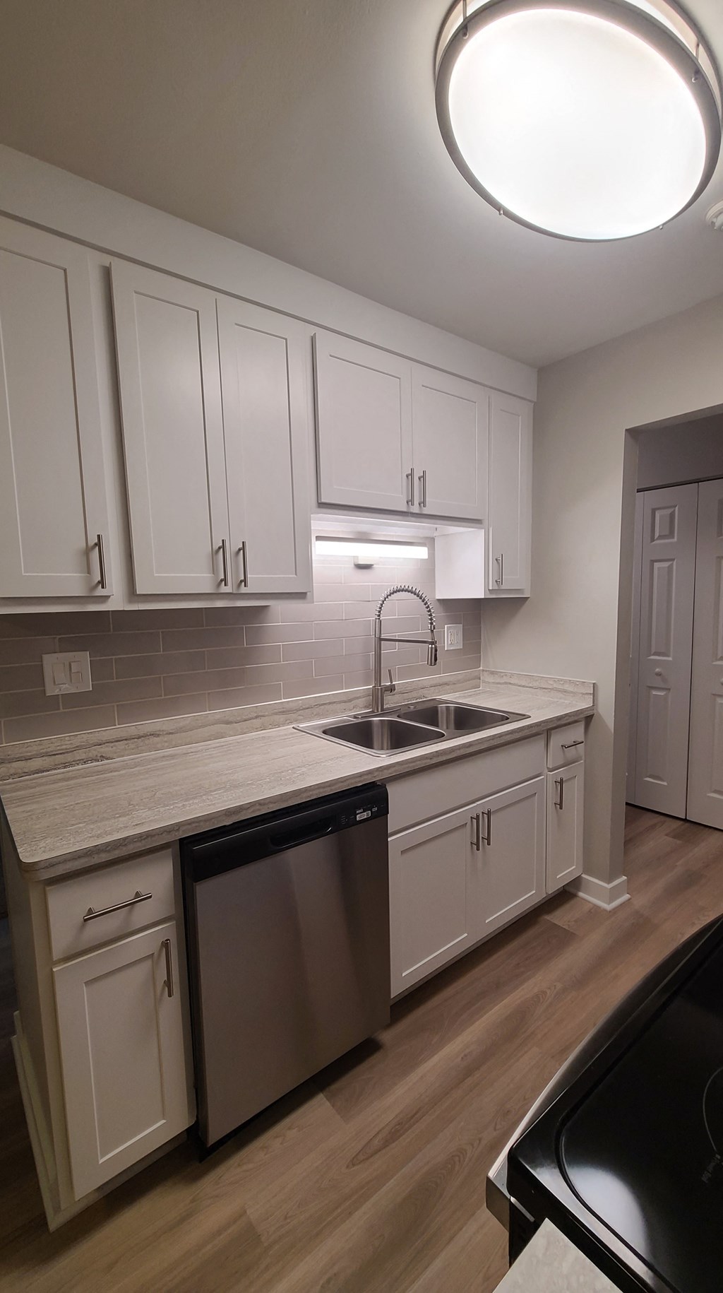 an empty kitchen with white cabinets and a sink