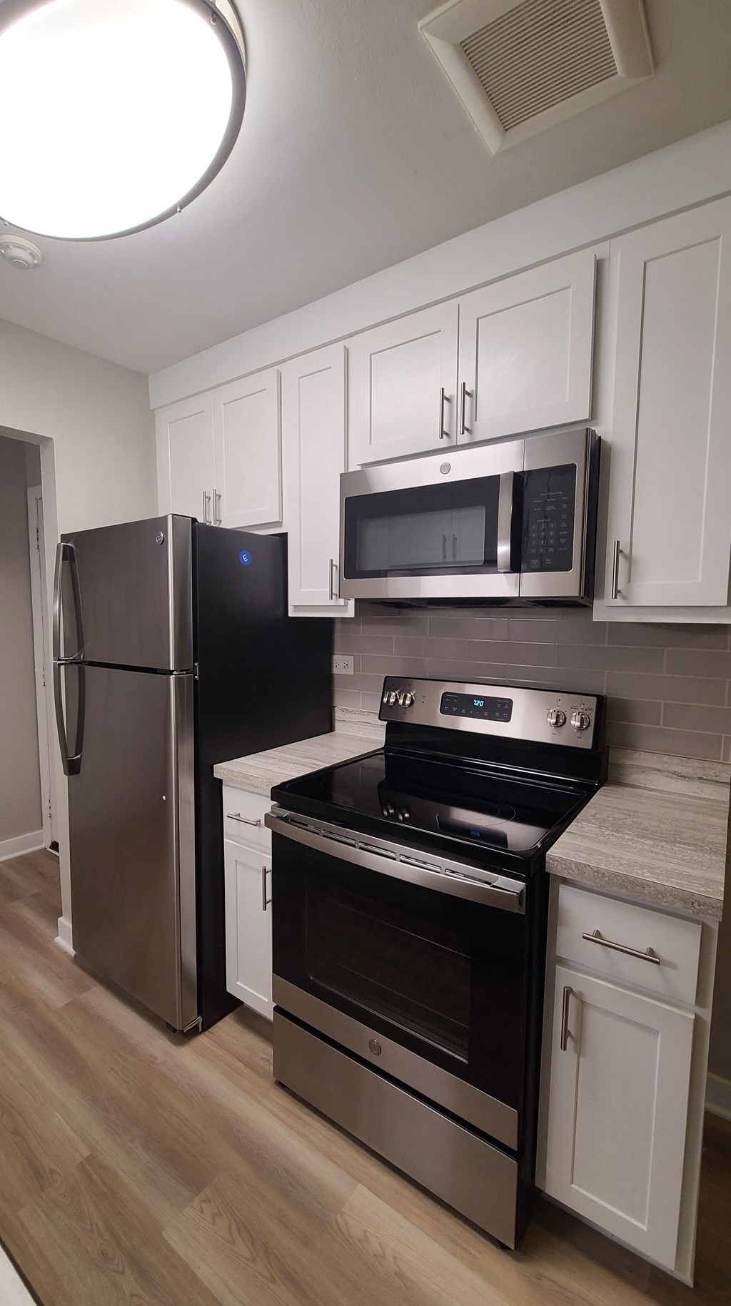 a kitchen with stainless steel appliances and white cabinets