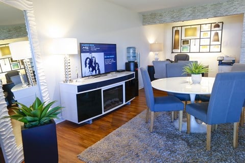 a living room with a dining room table and a television