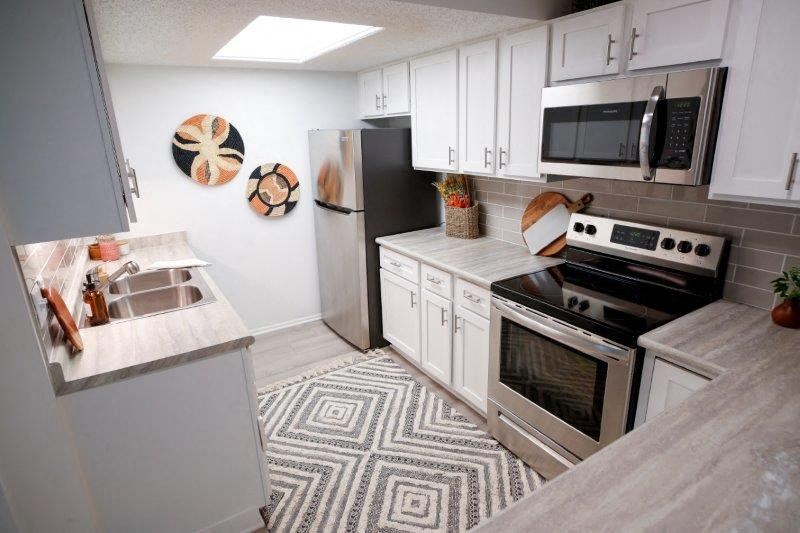 a kitchen with stainless steel appliances and white cabinets