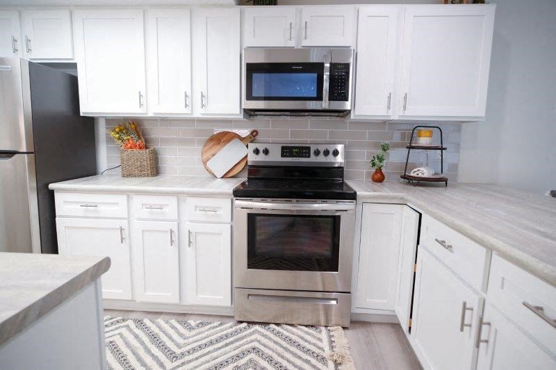 a white kitchen with a stove and a microwave