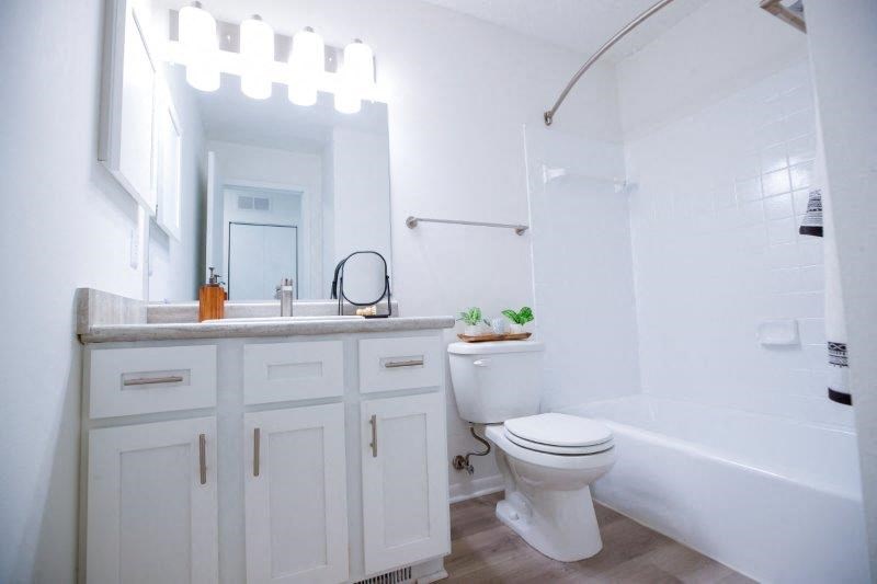 a white bathroom with a toilet and a sink