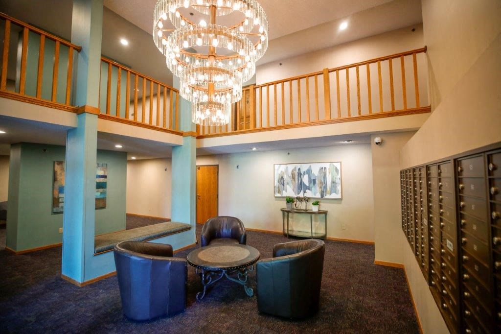 a lounge area with blue chairs and a chandelier