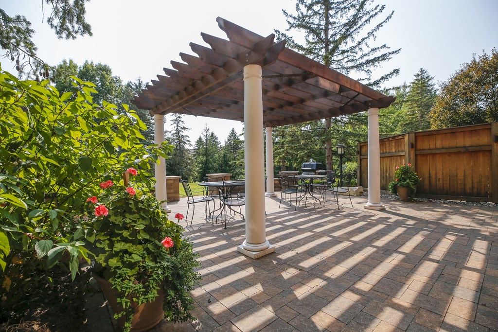 a patio with a pergola and a table and chairs