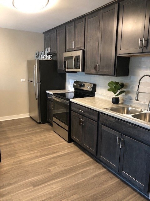 a kitchen with stainless steel appliances and dark cabinets