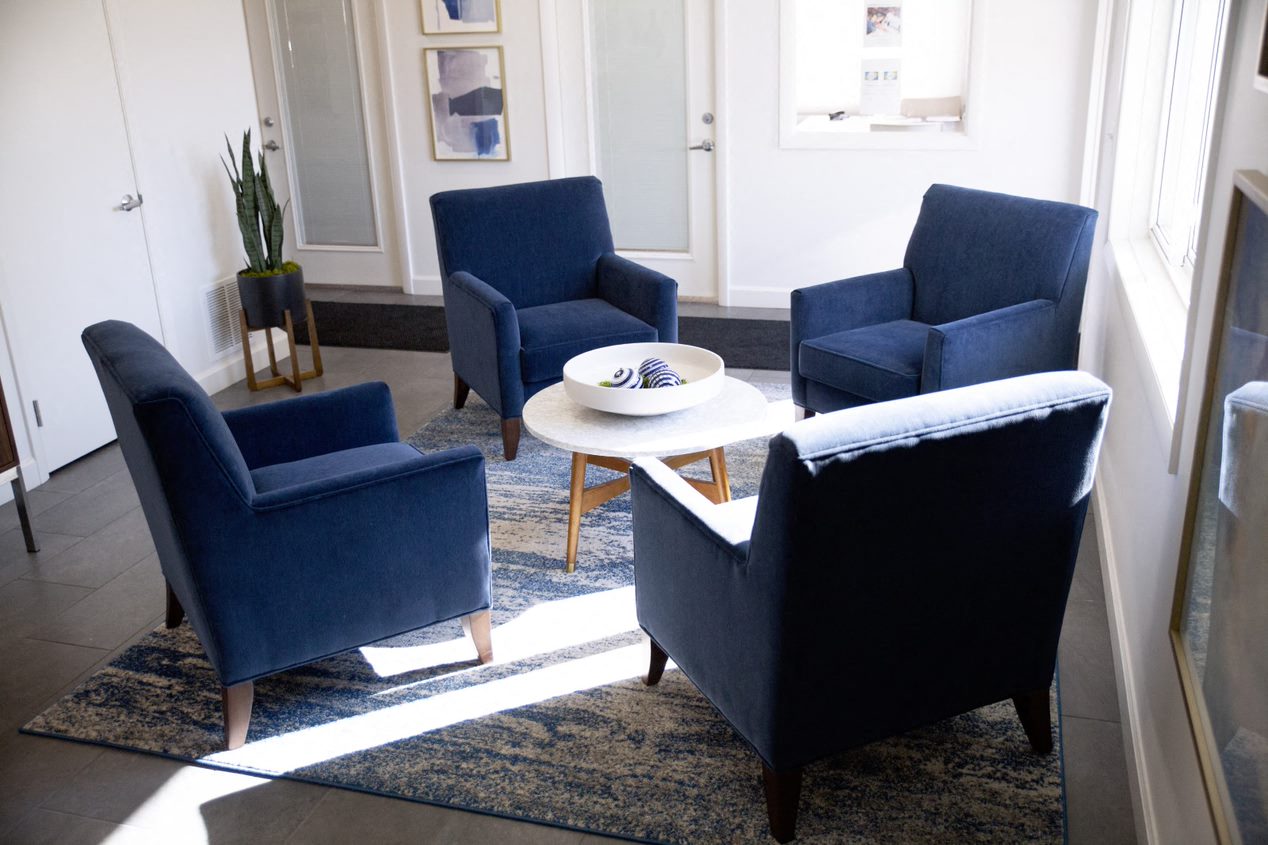 a living room with blue chairs and a coffee table