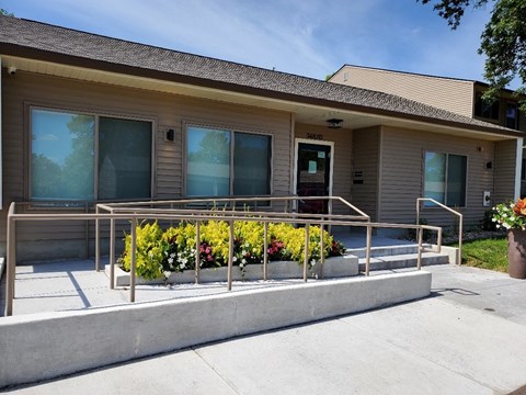 a building with a ramp and flowers in front of it