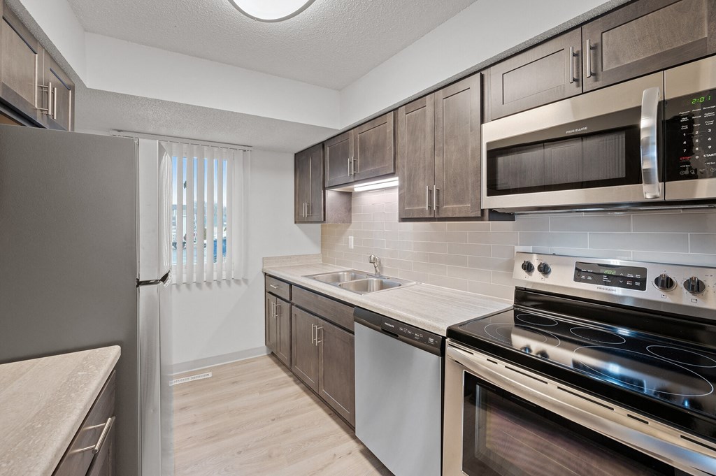 a kitchen with stainless steel appliances and wooden cabinets