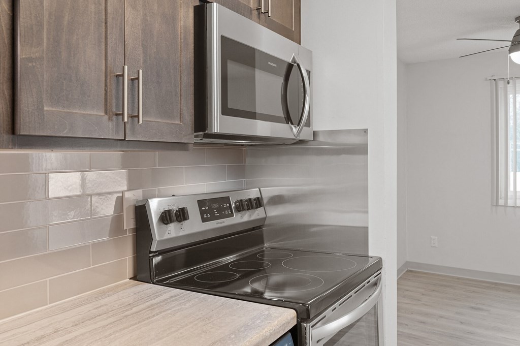 an empty kitchen with a stove and a microwave