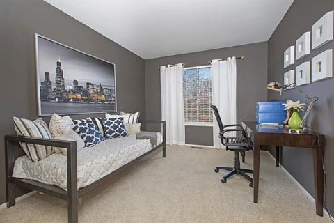 A living room with a couch, chair, and a large picture of a city skyline on the wall.