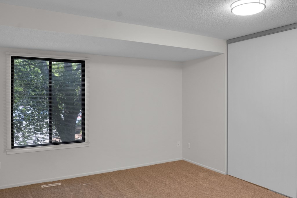 A room with a window and a closed door.