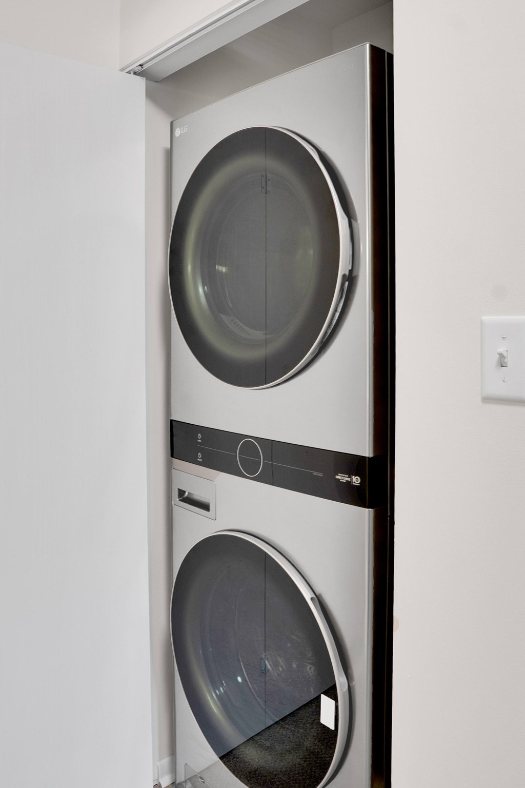 A white and black front loading washing machine in a cabinet.