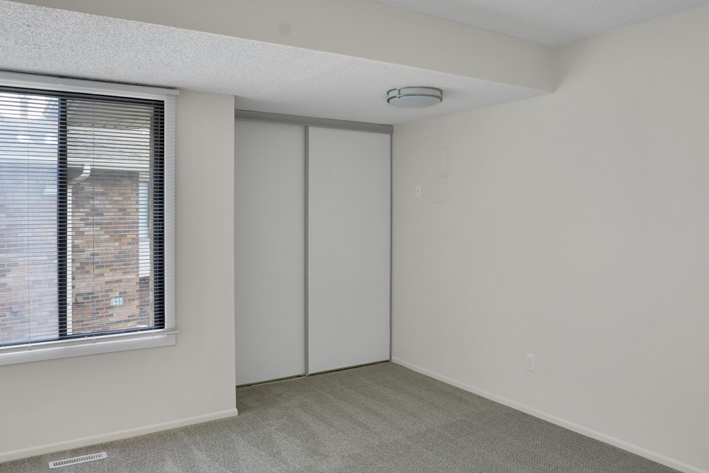 A room with a window and a sliding door.