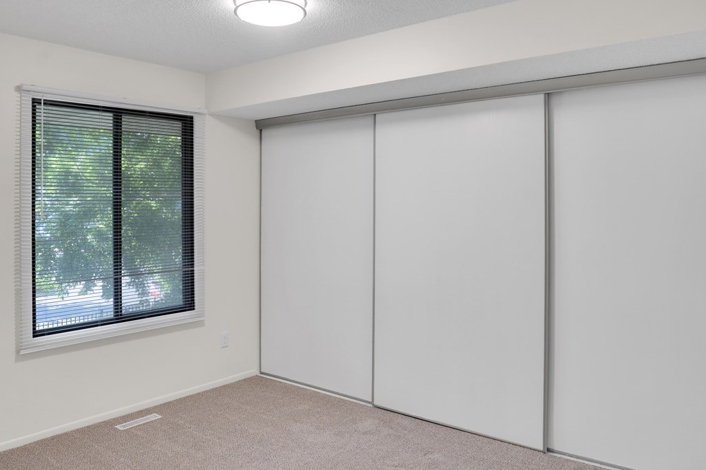 A room with a window and sliding doors.