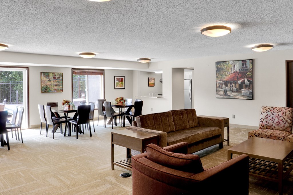 A living room with a couch, chairs, and a dining table.