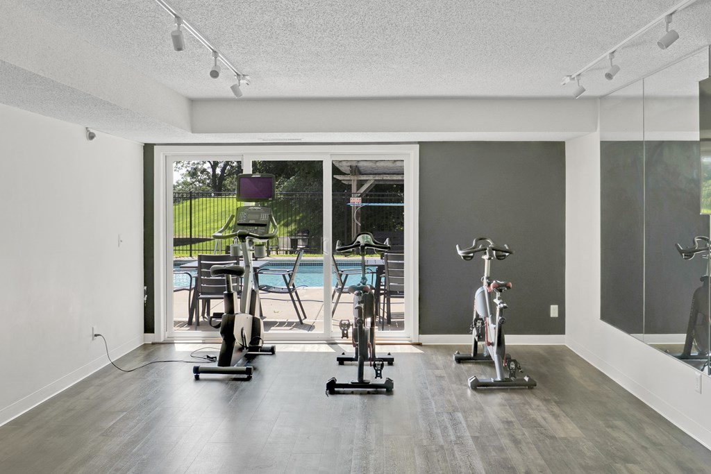 A room with a pool table and exercise bikes.