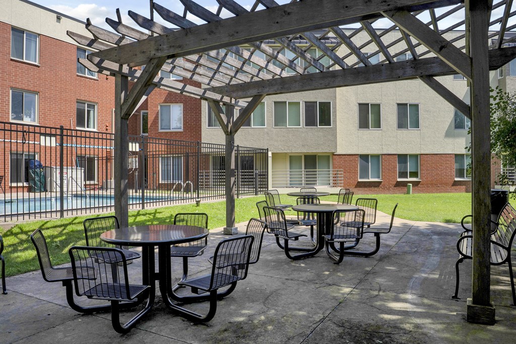 A patio with a table and chairs under a pergola.
