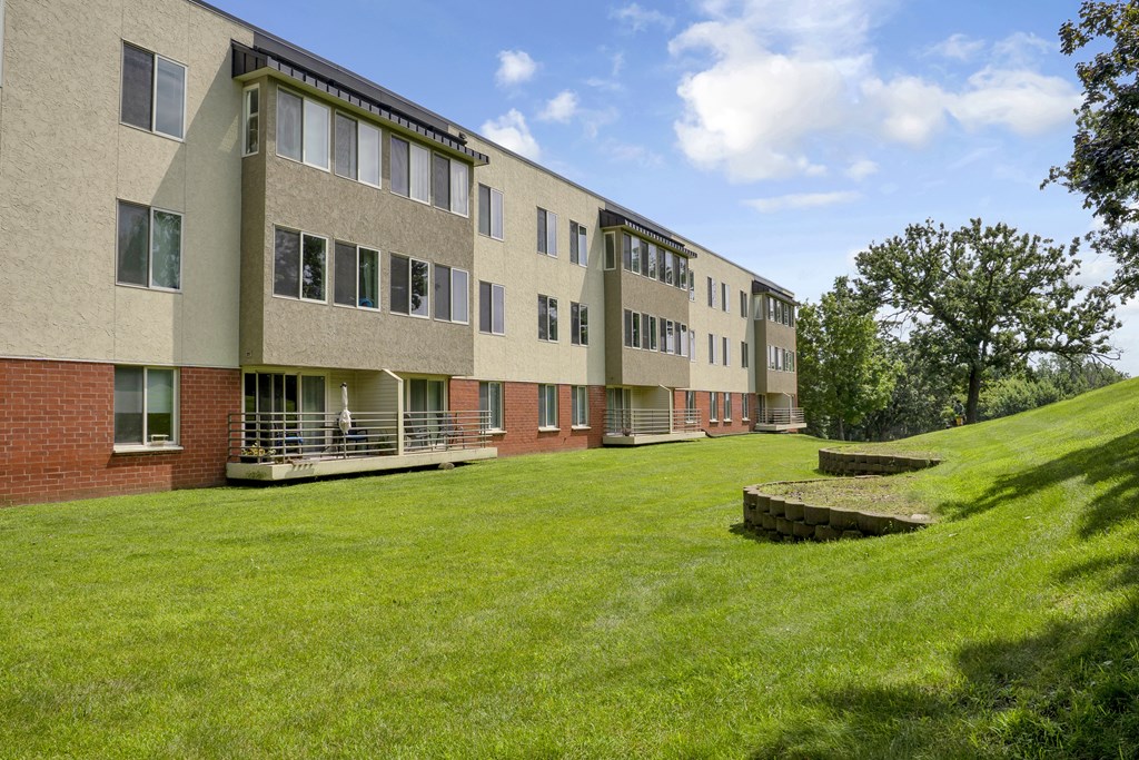 A long building with a green lawn in front.