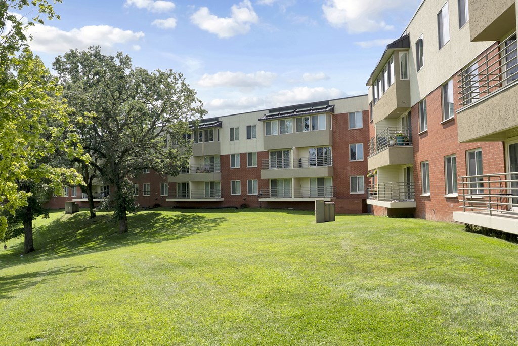 A grassy area in front of apartment buildings.