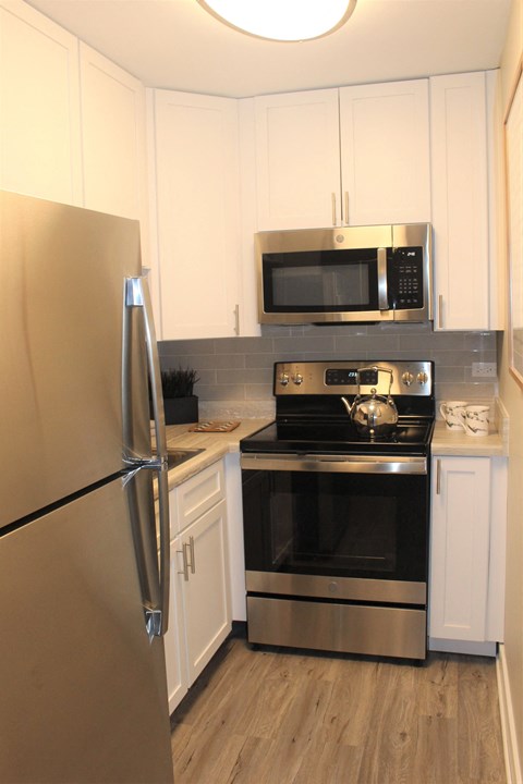 a kitchen with stainless steel appliances and white cabinets