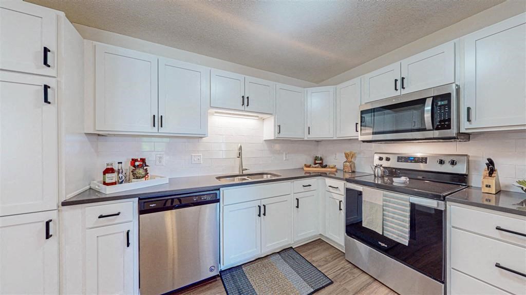a kitchen with white cabinets and a stove and a microwave