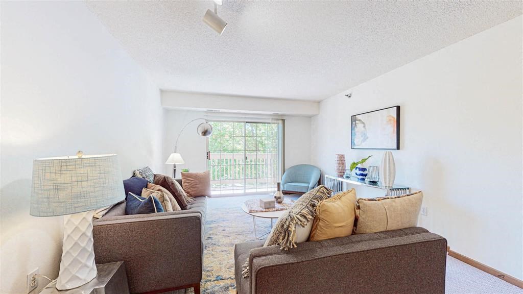 a living room with couches and chairs and a window