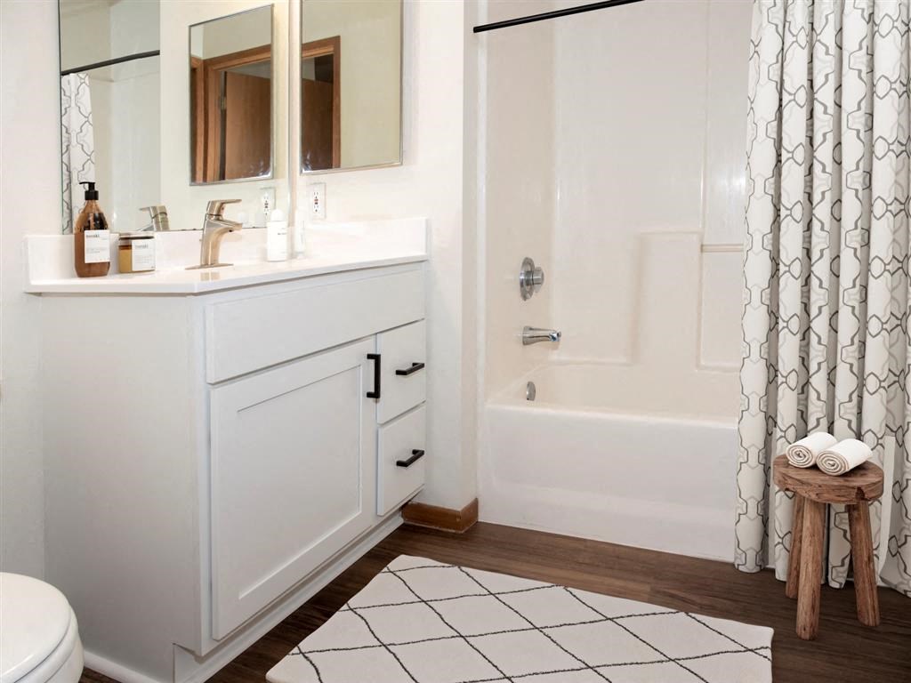 a white bathroom with a shower and a sink