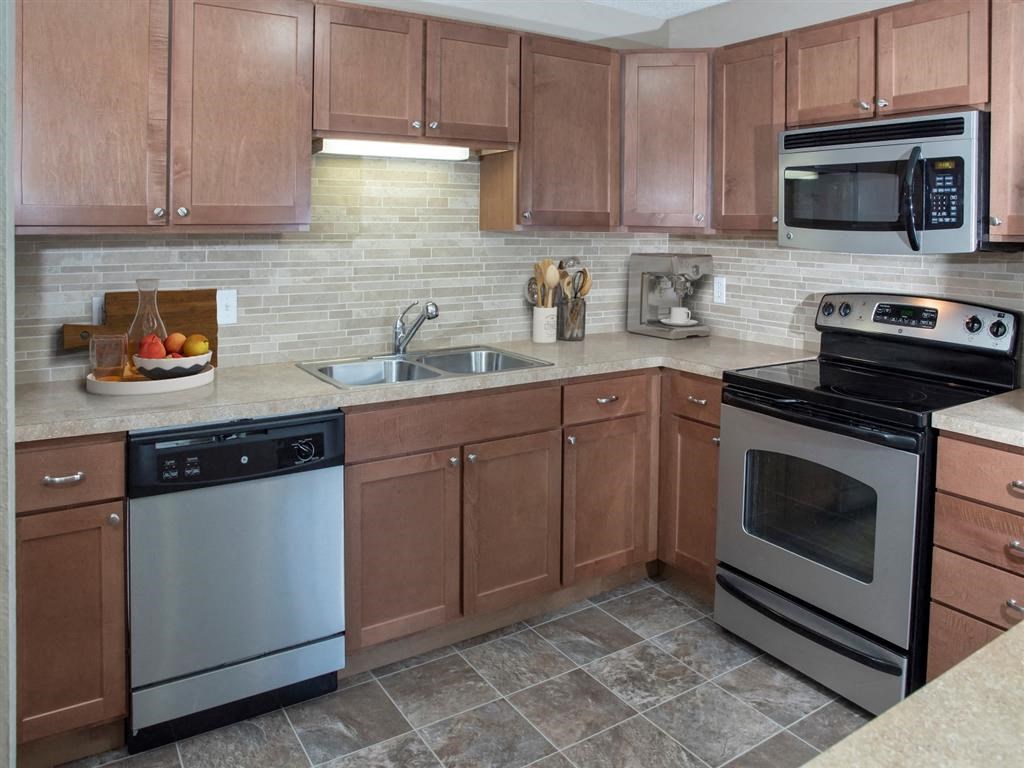 a kitchen with stainless steel appliances and wooden cabinets