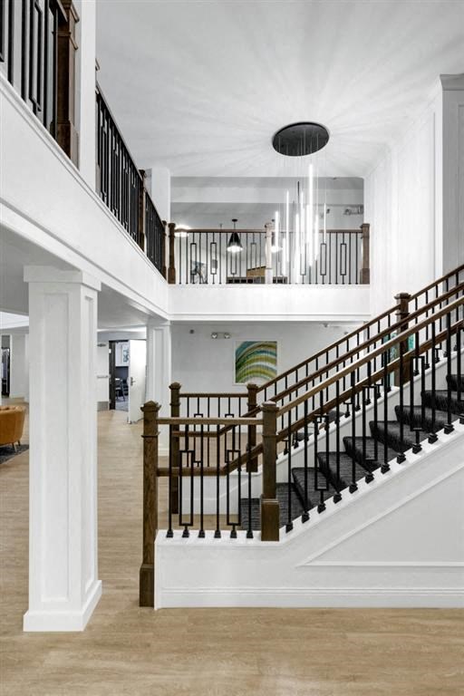 a sweeping staircase in a home with white walls and wood floors