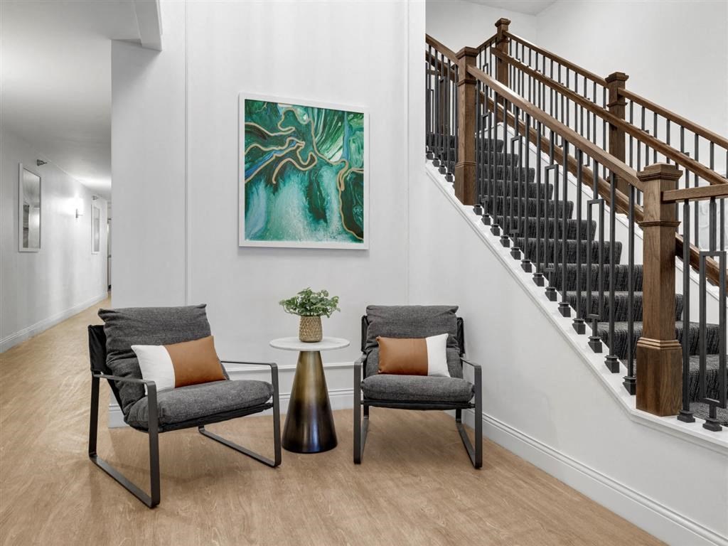 a living room with two chairs and a staircase