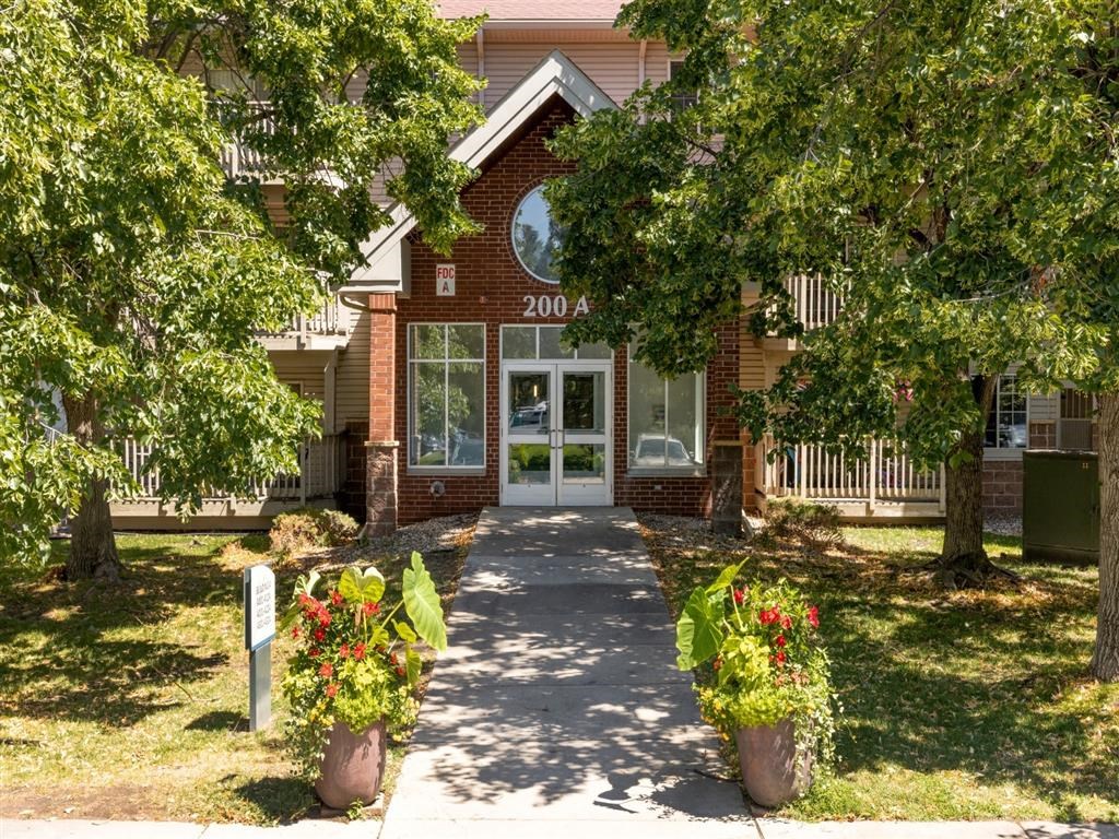 the front entrance of a red brick house with trees and a sidewalk
